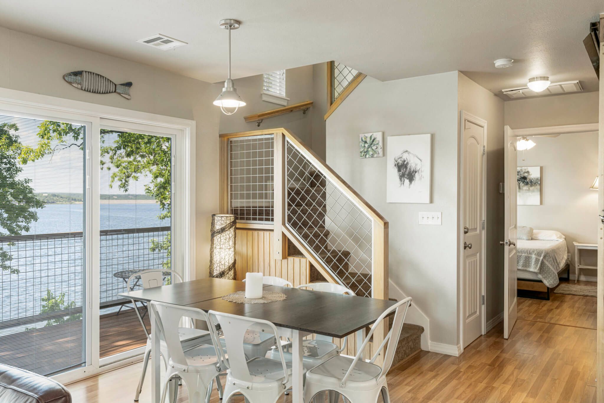 Un interior moderno con comedor, escalera y dormitorio.