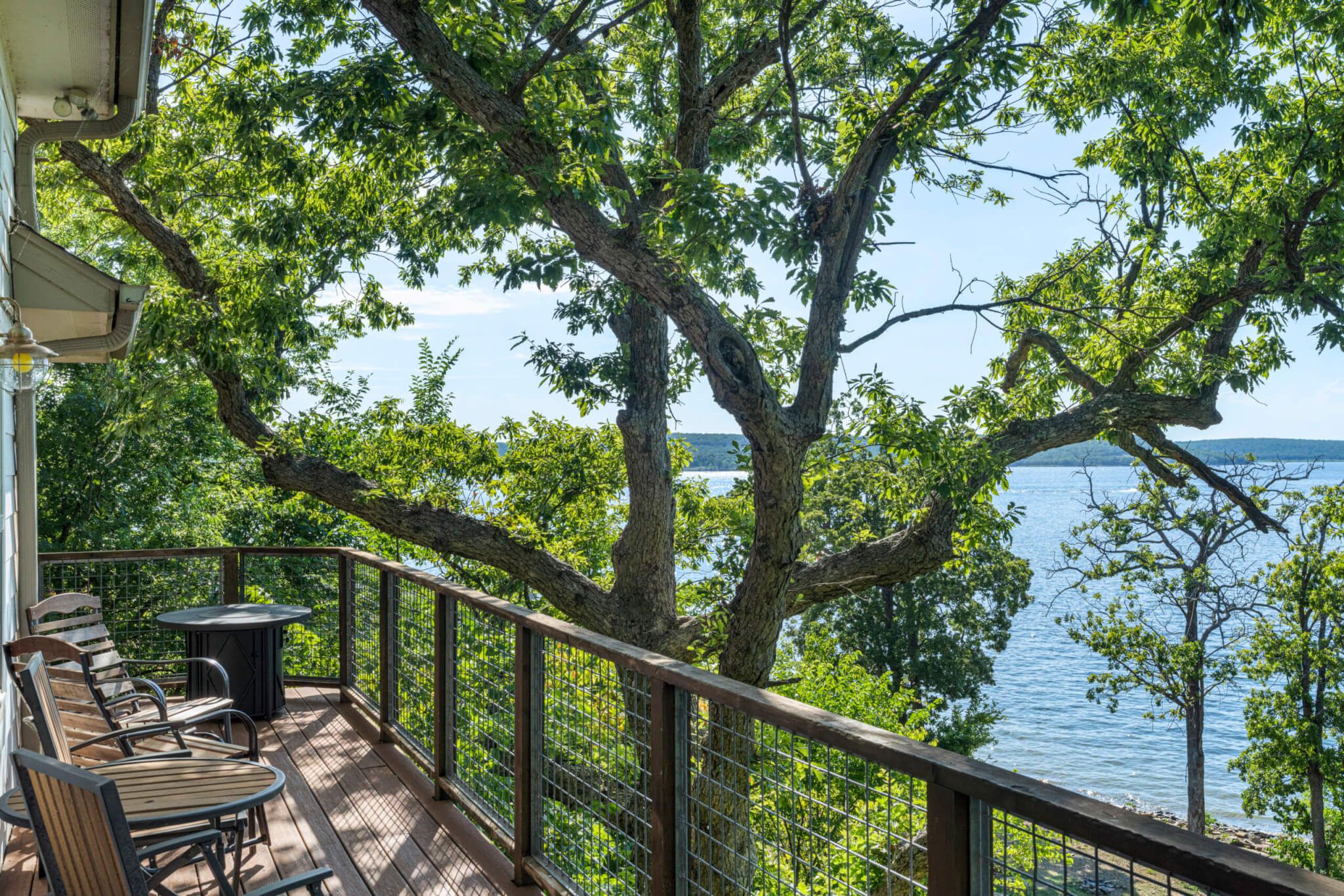 Une terrasse dotée de mobilier d’extérieur, offrant une vue sur un lac.