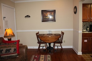 Enjoy meals in this cozy dining area with a wooden table and comfortable seating for four.