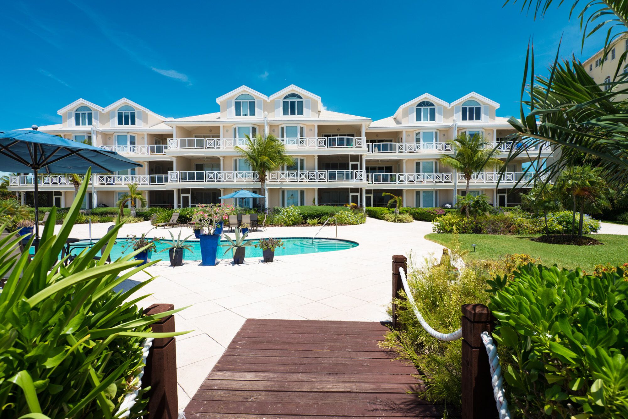 Un resort con piscina, varios balcones y exuberante vegetación.
