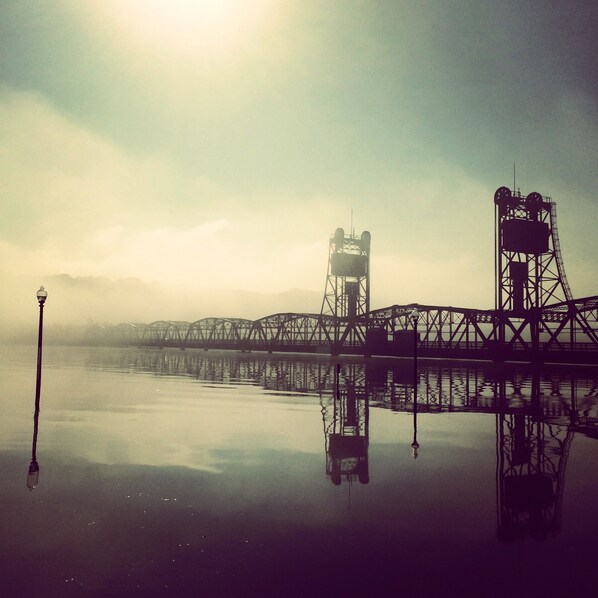 A bridge with a metal framework and a platform, reflecting in calm water. - Stillwater's Third Street Inn (Stillwater)