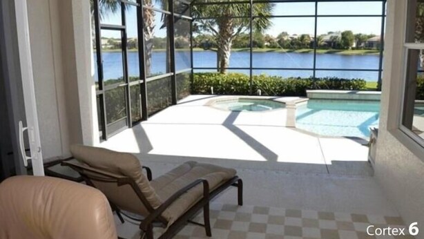 Une terrasse ensoleillée avec une piscine, des chaises longues et une vue sur un lac.