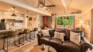 Un intérieur chaleureux avec un canapé en cuir, un bar en bois et une cheminée en pierre.