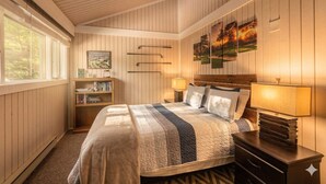 Une chambre à coucher avec un lit, des lampes de chevet, une table de chevet, une bibliothèque et un tableau au mur.
