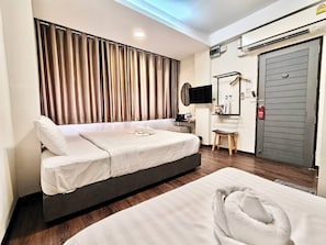 A modern hotel room with a bed, bedside table, TV, and a wardrobe. - Kim Korner Hotel (Bangkok)