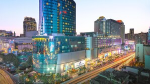 A modern hotel with a curved facade, multiple floors, and a prominent 'Novotel' sign. - Kim Korner Hotel (Bangkok)