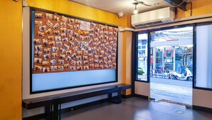A wall with a corkboard displaying numerous photos. - Kim Korner Hotel (Bangkok)