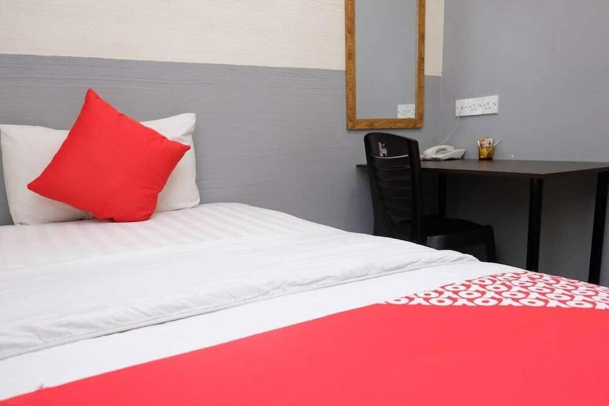 Una habitación de hotel con una cama, un escritorio y una silla.