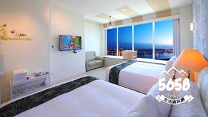 A hotel room with two beds, a TV, a window with a city view, and a balcony. - 85 Eagle Hotel (Kaohsiung)