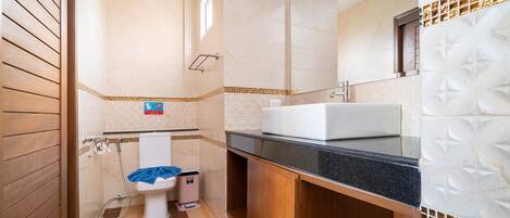 A bathroom with a toilet, sink, and shower.