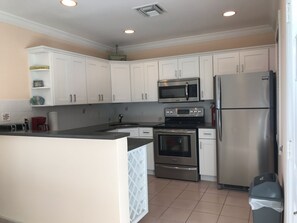 Enjoy cooking in this well-equipped kitchen with a sink, microwave, oven, and refrigerator.