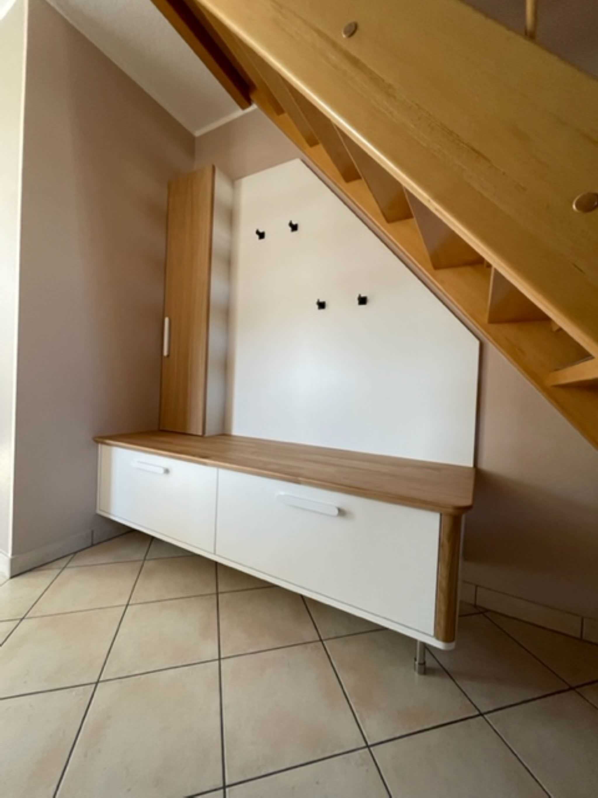 Une pièce d’angle avec une banquette intégrée et un escalier en bois.