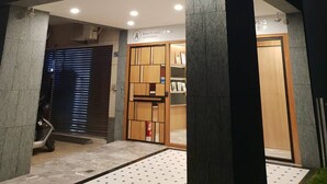 A hotel entrance with a modern design, featuring a prominent illuminated sign and a logo. - Beauty Avenue Inn (Kaohsiung)