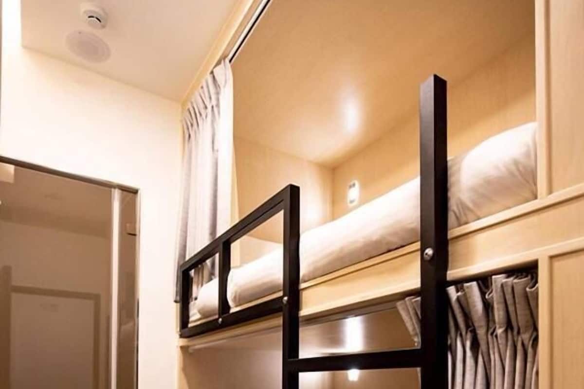 A bunk bed room with a sliding door and a shower area.