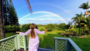 A person standing on a porch with a view of a garden and a rainbow. - Amazing VIEWS, Spacious, Farmstead Living, Hosts with Aloha (Hawi)