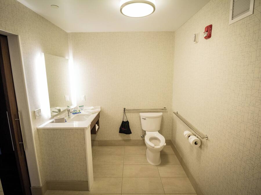 A small bathroom with a toilet, sink, and mirror.