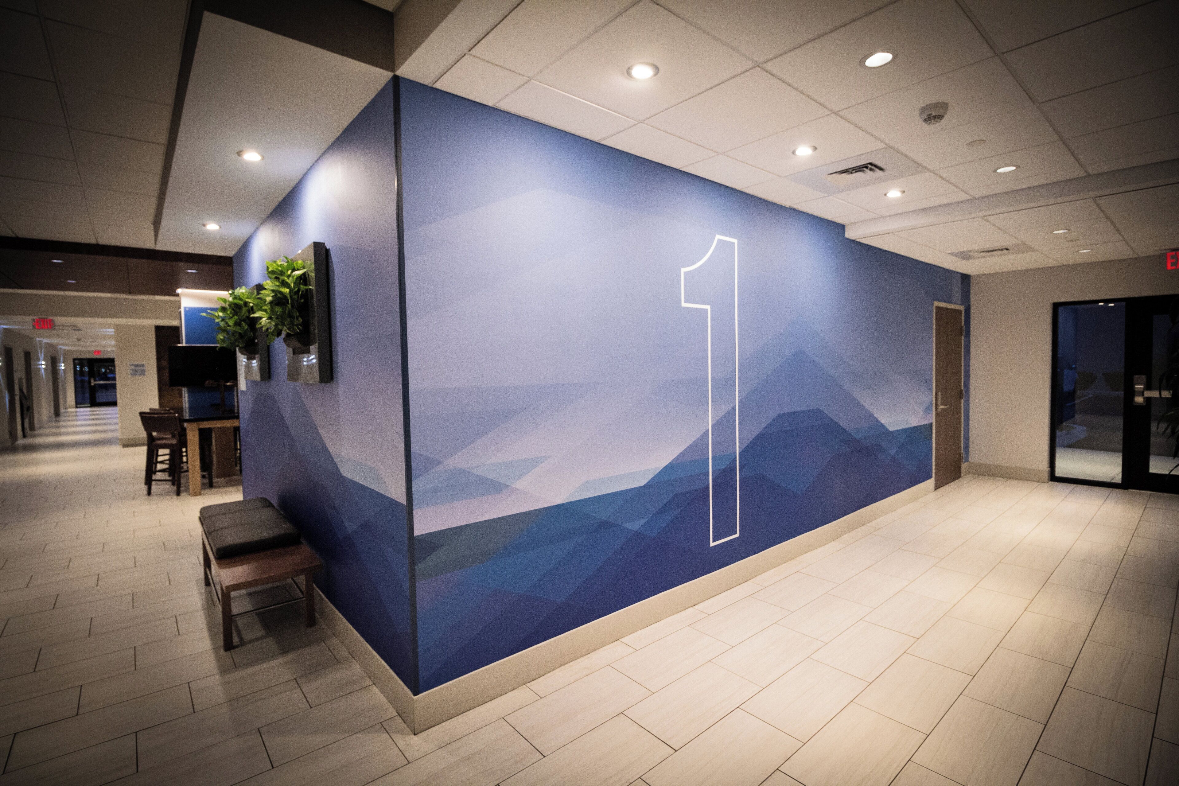 A modern interior with a wall featuring a mountain landscape design and a prominent number 1.
