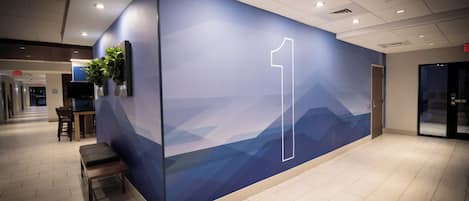 A modern interior with a wall featuring a mountain landscape design and a prominent number 1.