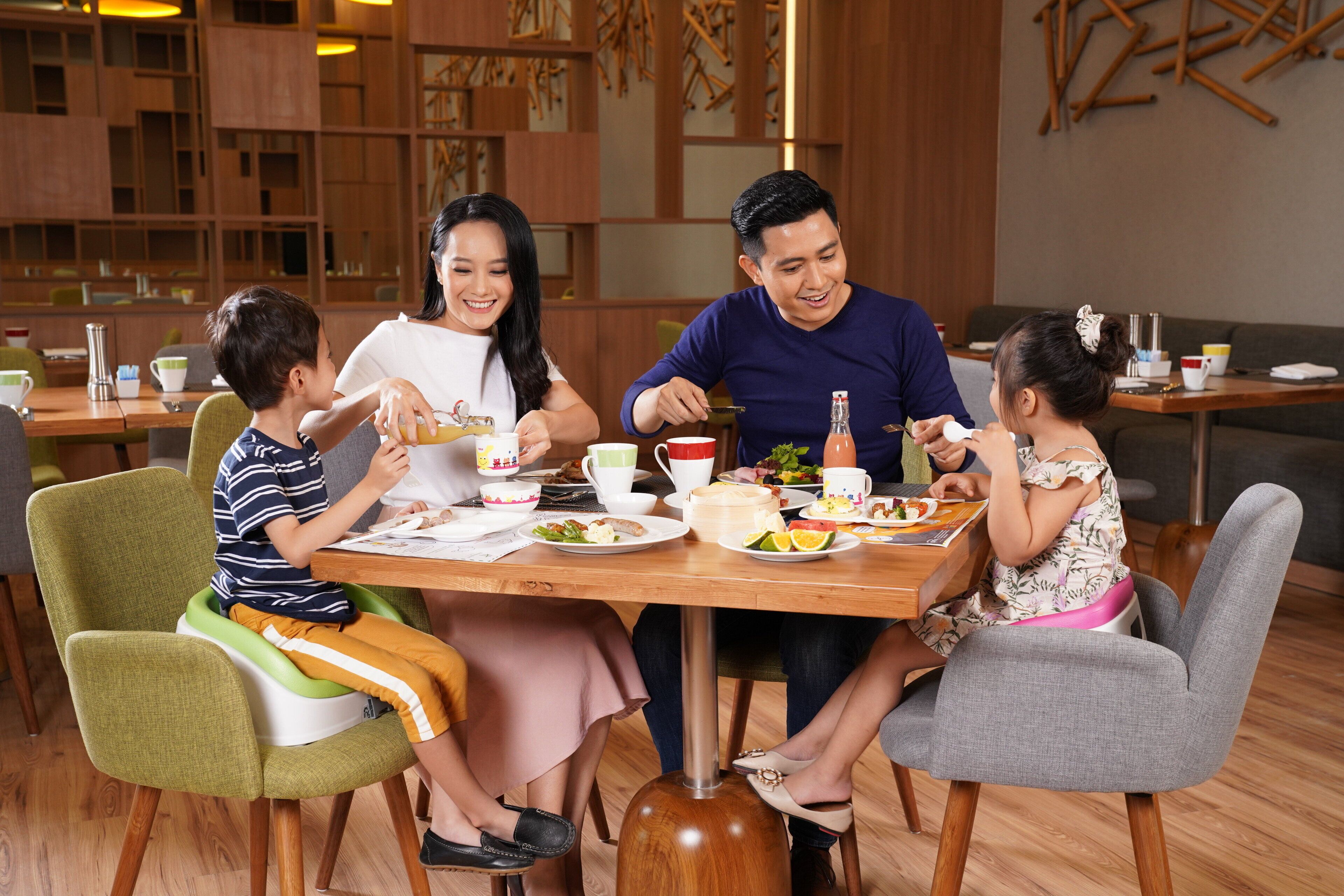 A family dining at a wooden table in a modern restaurant with a casual setting.