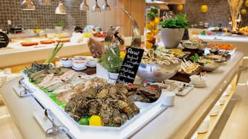 Un bufé con diversas opciones de mariscos, incluyendo ostras, camarones y langosta.