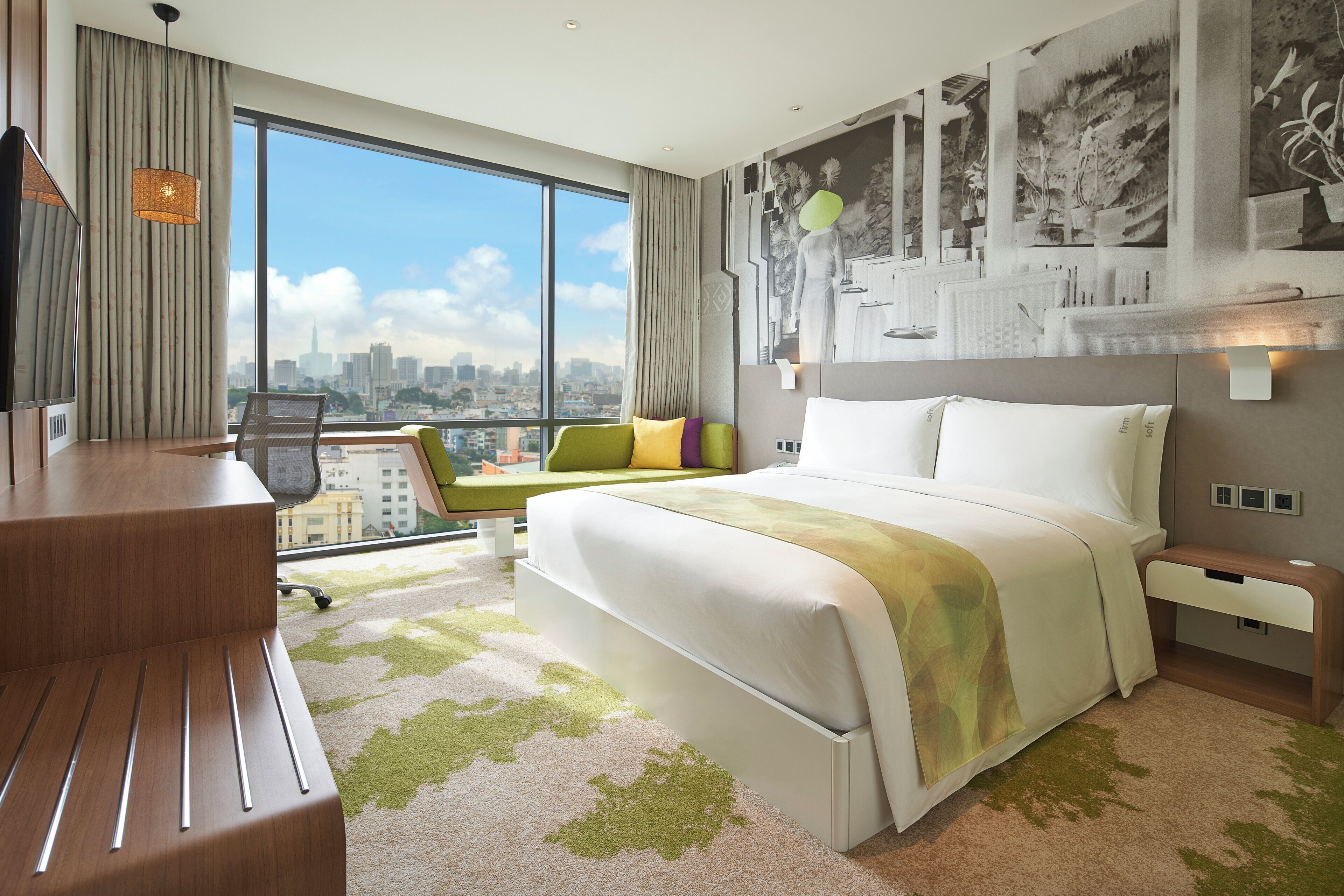 Une chambre d’hôtel avec un grand lit, un bureau, une chaise et une vue sur le paysage urbain.
