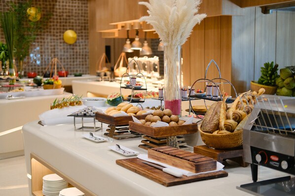 Ein reichhaltiges Buffet mit verschiedenen Speisen und einer Kaffeemaschine.