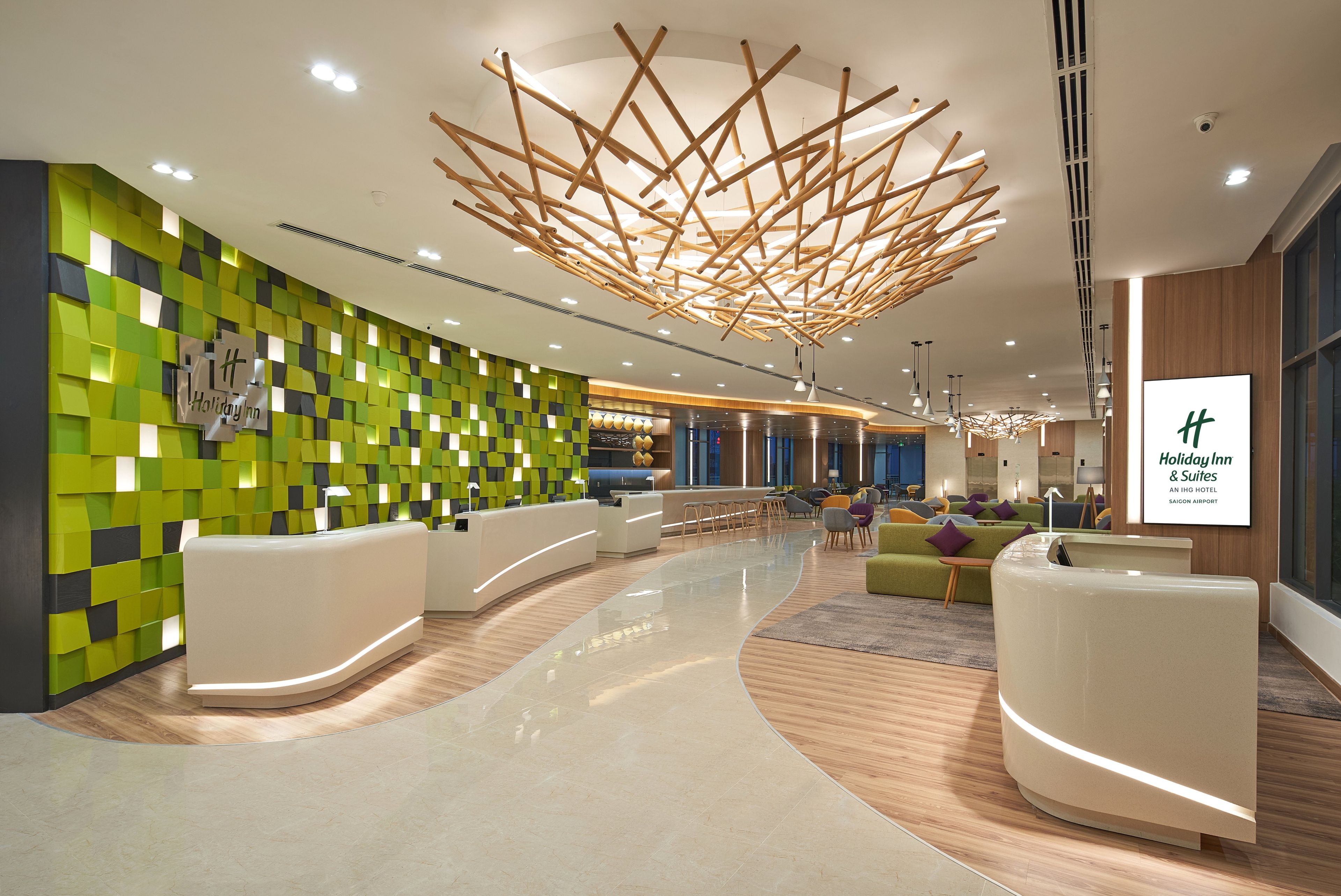 Un vestíbulo de hotel moderno con una recepción, un diseño de pared verde y negro, y un techo de madera.