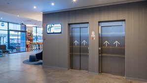 A Holiday Inn Express lobby with two elevators, a reception area, and a view of the street outside. - Holiday Inn Express Porto City Center by IHG (Porto)