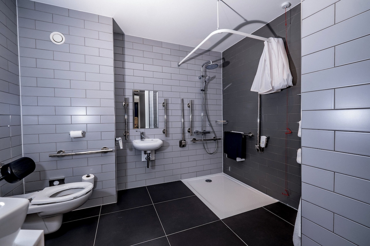 A modern bathroom with a toilet, sink, and shower.