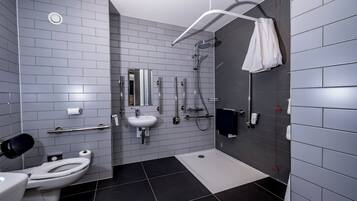 A modern bathroom with a toilet, sink, and shower.