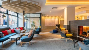 A modern lounge area with sofas, chairs, and a fireplace.