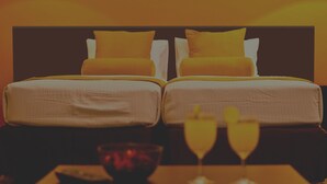 A double bed with yellow pillows and a dark headboard.