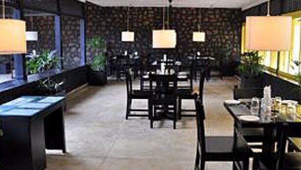 A modern hotel lobby with a central seating area, a reception desk, and ambient lighting.