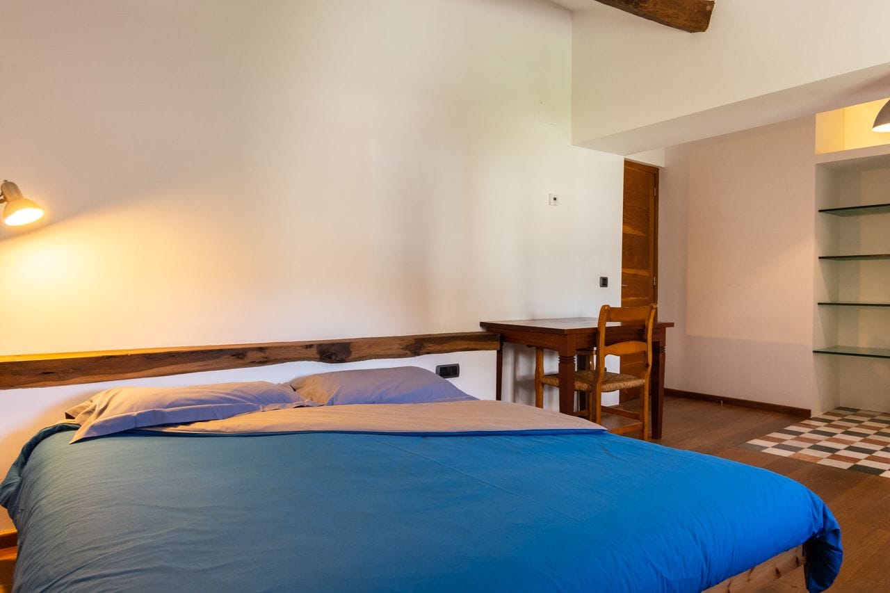 Una camera da letto con un letto, una scrivania e una sedia.