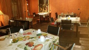 A dining area with tables set for two, featuring floral tablecloths and white tableware. - La Costa de Mollo (Mollo)