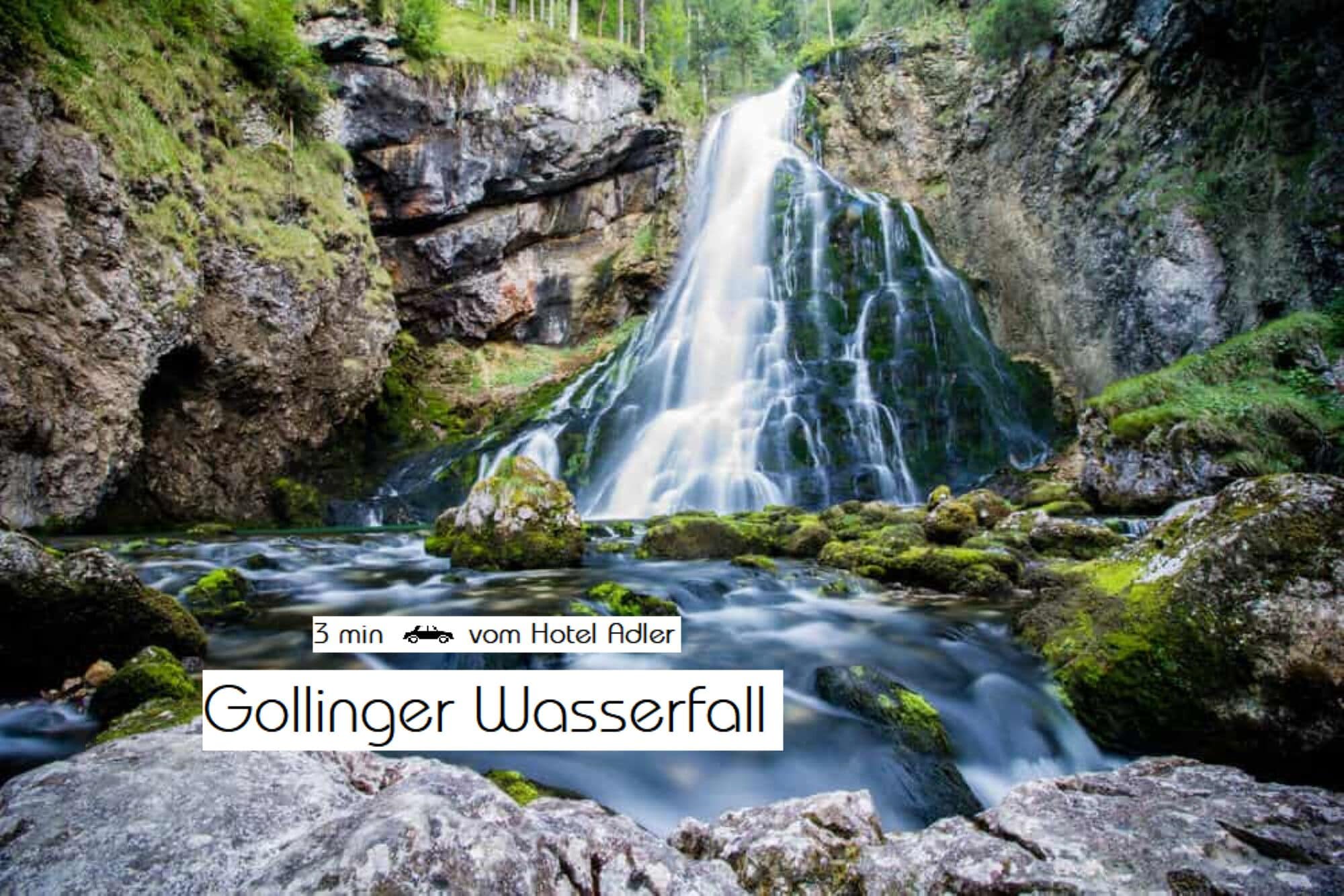 A waterfall with a rocky foreground and lush greenery.