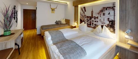 Una habitación de hotel moderna con una cama grande, un escritorio y un ventilador de techo.