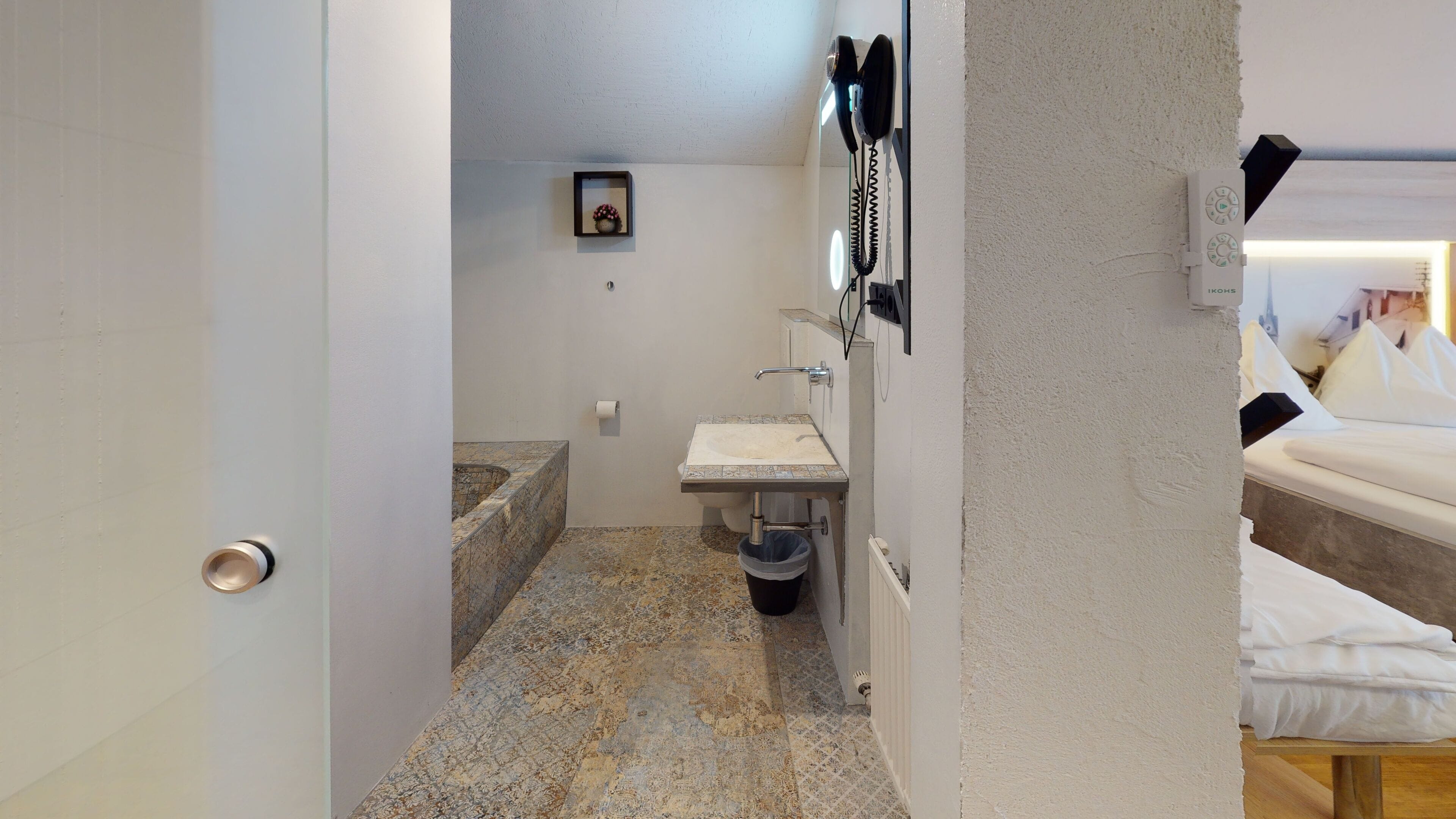 Un baño con lavamanos, inodoro y un pequeño estante con un cuadro.