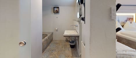 A bathroom with a sink, toilet, and a small shelf with a picture.