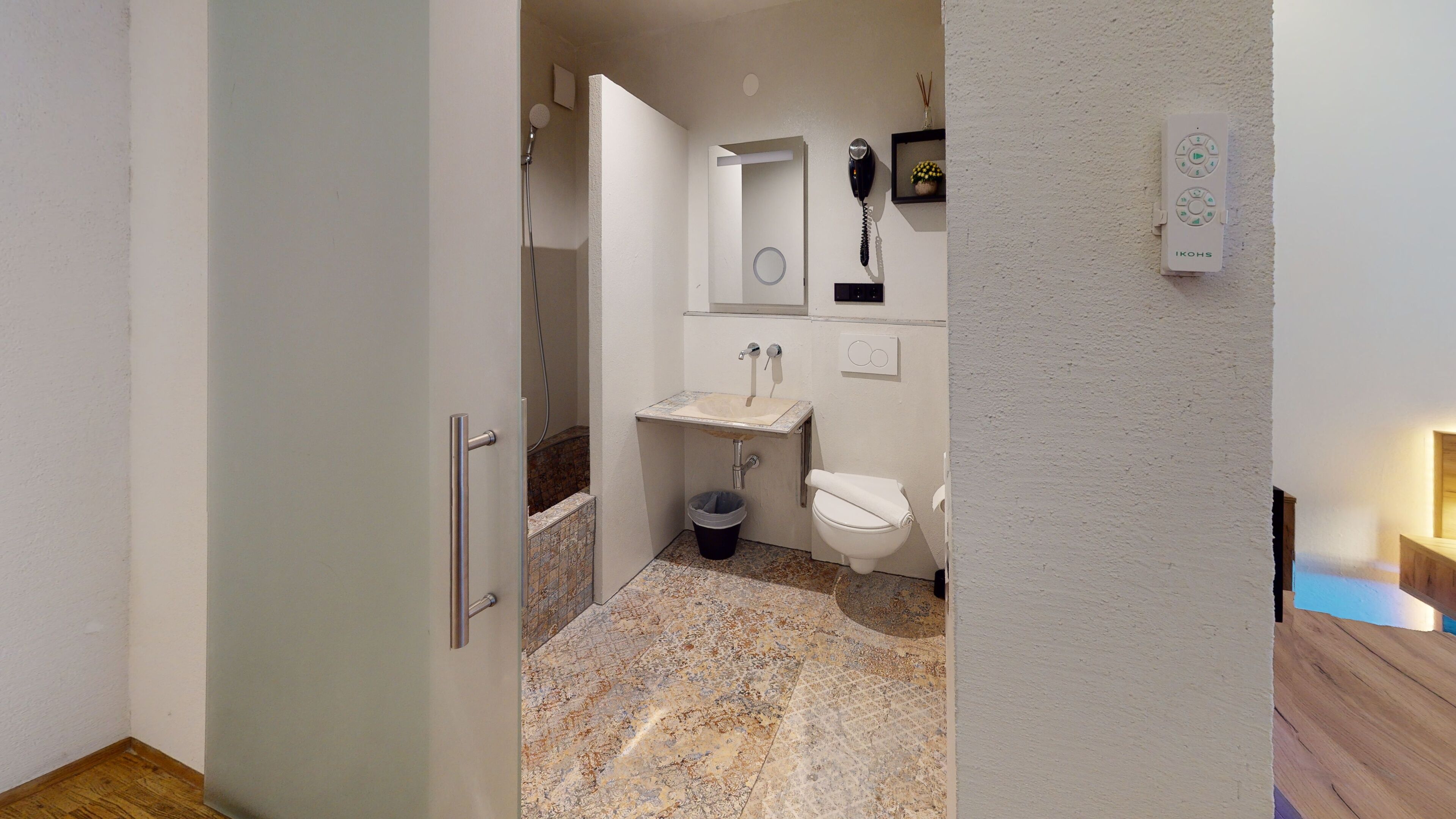 Ein kleines Badezimmer mit Waschbecken, Toilette und Dusche.