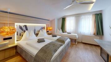 Habitación de hotel moderna con una cama grande, dos mesitas de noche, un escritorio y vistas de la ciudad a través del ventanal.