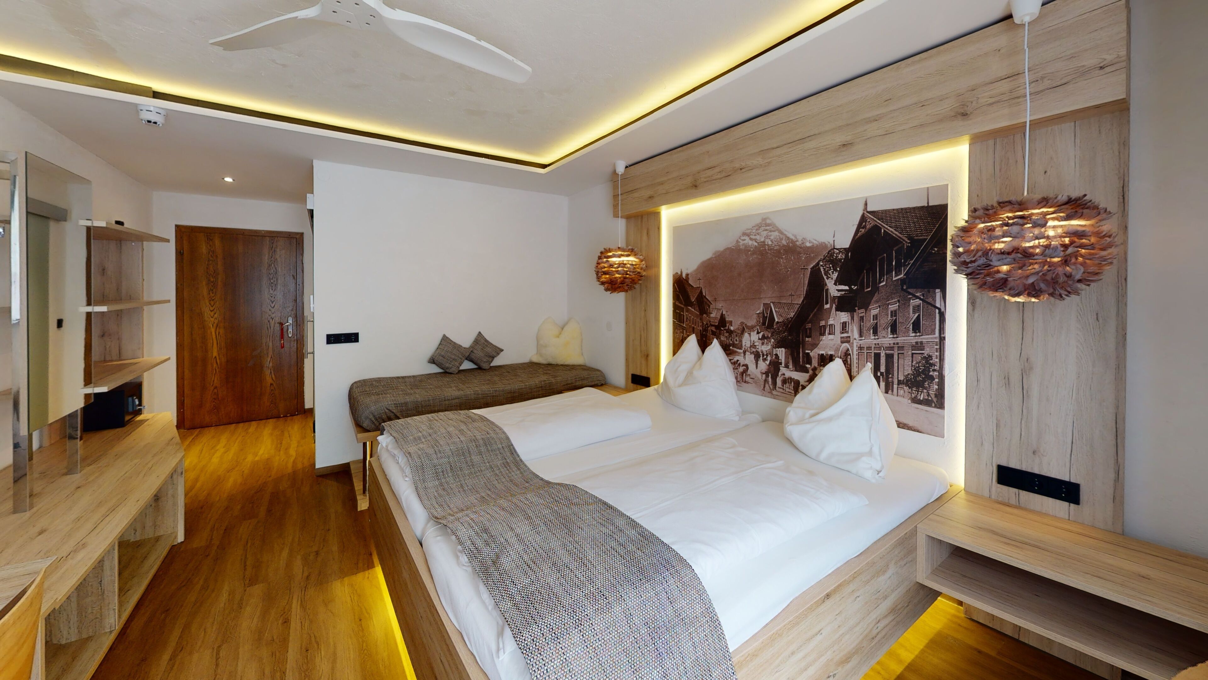 A modern hotel room with a large bed, a wooden headboard, and a cityscape mural.