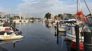 A marina with various boats docked, calm water, and a clear sky. - Kleines Strandhotel (Timmendorfer Strand)