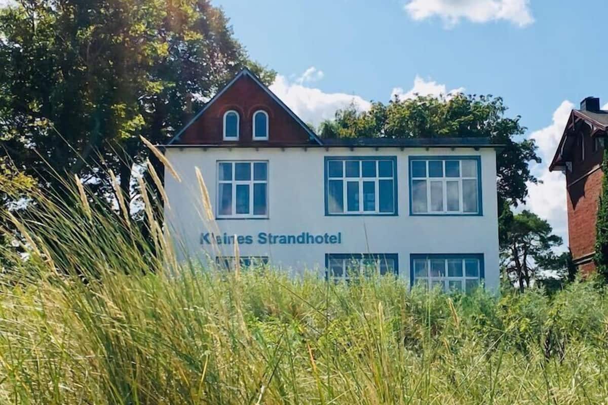 A two-story building with the sign "Kleines Strandhotel" on the side.
