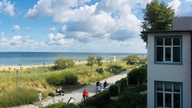A coastal path with people walking and cycling, leading to a beach. - Kleines Strandhotel (Timmendorfer Strand)