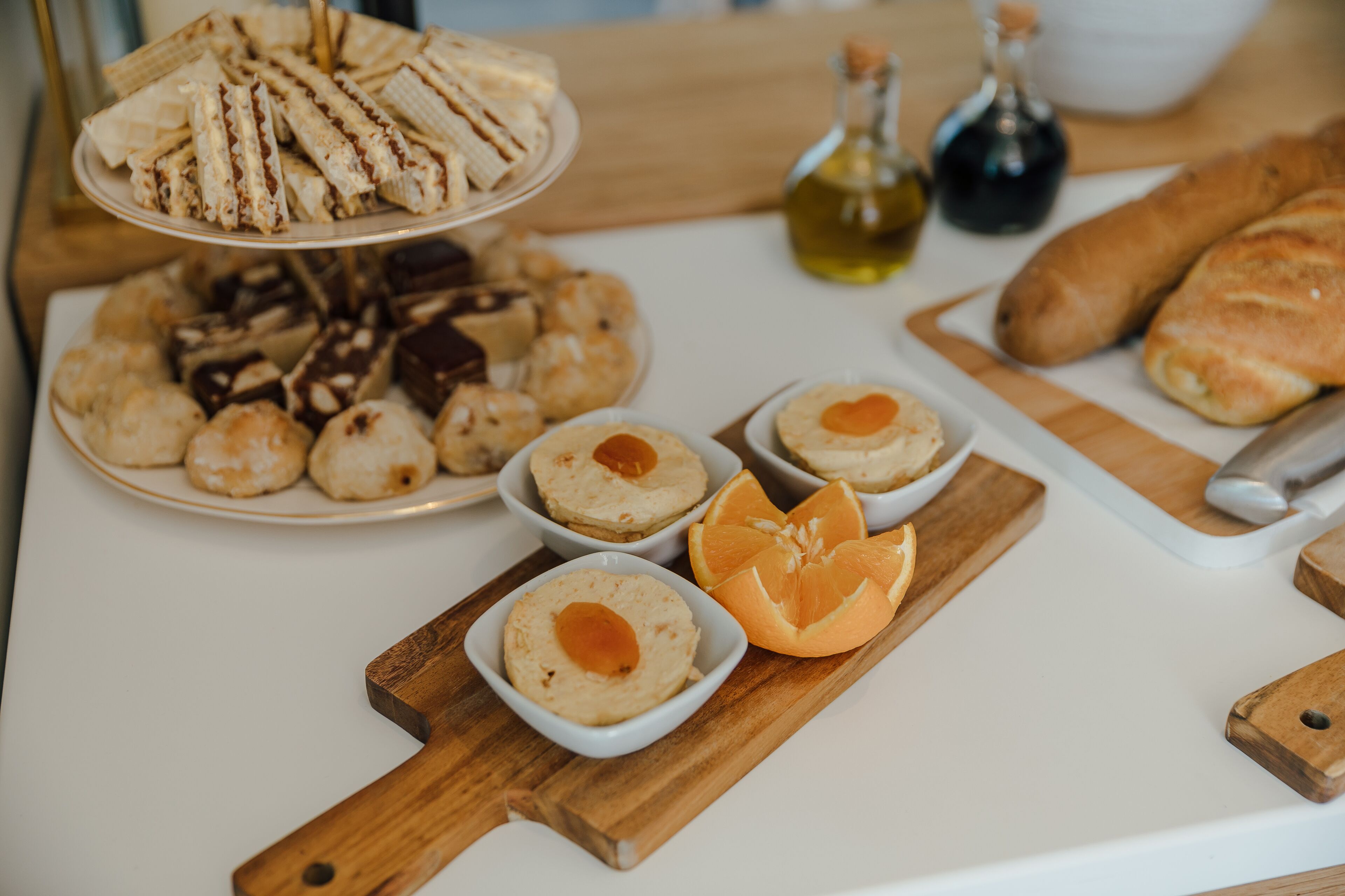 A table with various food items including sandwiches, pastries, and a bowl of soup.
