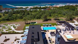 Une piscine sur le toit avec vue sur l’océan et une jetée visible au loin.