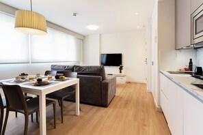 Un espace de vie moderne comprenant un coin repas, un canapé et une cuisine.