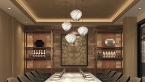 A modern dining area with a long table set for six, surrounded by upholstered chairs. - Hoang Kim Hotel (Vientiane)