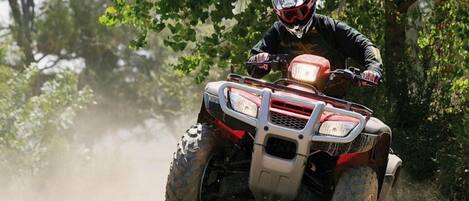 A person riding an ATV in a forested area.